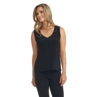 Woman wearing a black sleeveless top and leggings on a white background