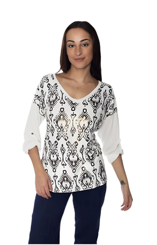 Woman wearing a white blouse with black pattern and dark pants on a white background, with 'Amoros' branding.