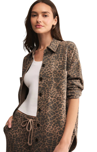 Woman wearing a leopard print shirt and pants on a beige background