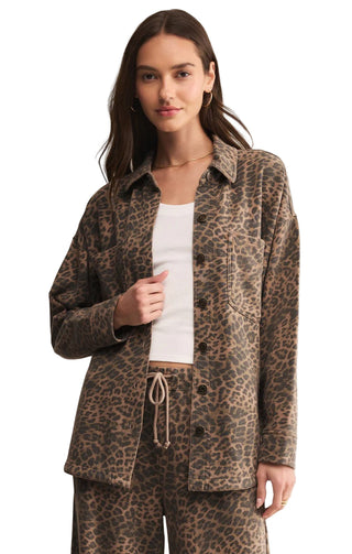 Woman wearing a leopard print jacket and pants on a beige background