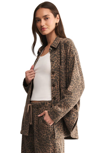 Woman wearing a leopard print jacket and pants on a beige background