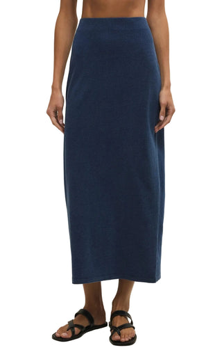 Person wearing a navy blue skirt on a plain background