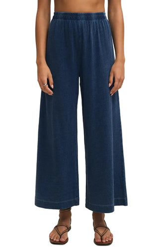 Person wearing blue wide-leg pants on a plain background