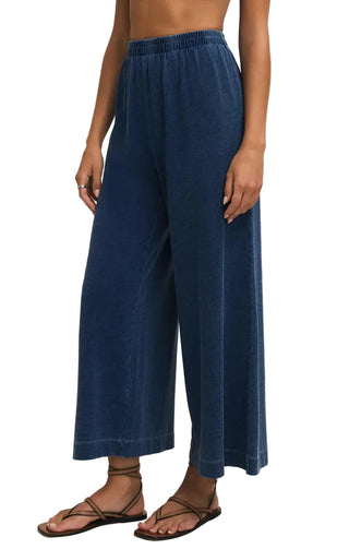 Person wearing blue wide-leg pants on a plain background