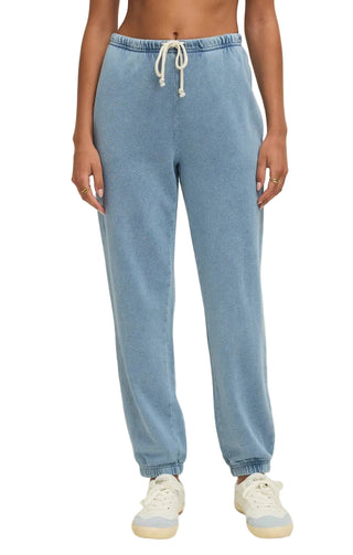 Light blue jogger pants worn by a person on a beige background