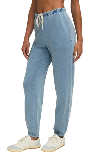 Light blue denim jogger pants worn by a person on a plain background