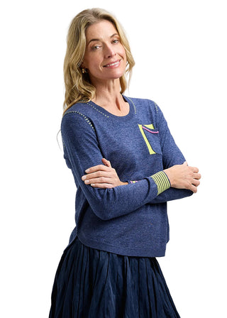 Woman wearing a blue sweater with a logo on a gray background