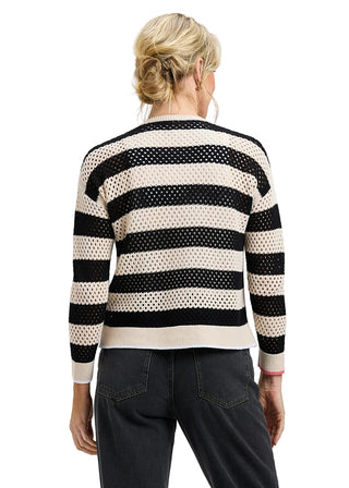 Person wearing a black and white striped sweater on a plain background