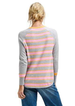 Person wearing a gray sweater with pink and yellow stripes on a plain background
