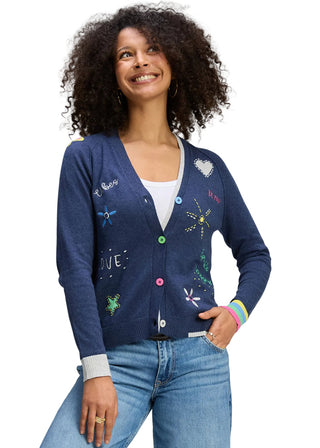 Woman wearing a blue cardigan with colorful buttons on a gray background