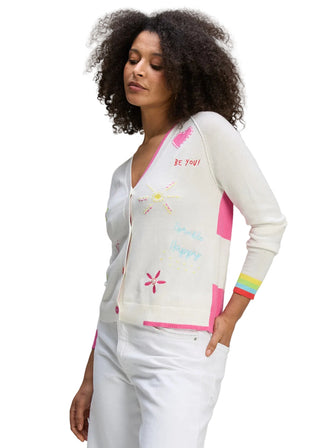 Woman wearing a colorful cardigan with text and patterns on a plain background