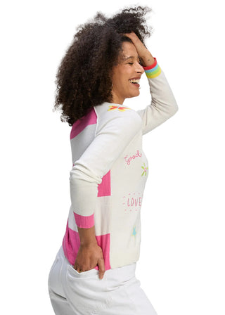 Woman wearing a colorful sweater with text and graphics on a gray background