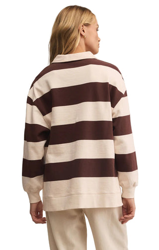 Person wearing a brown and white striped sweater on a plain background