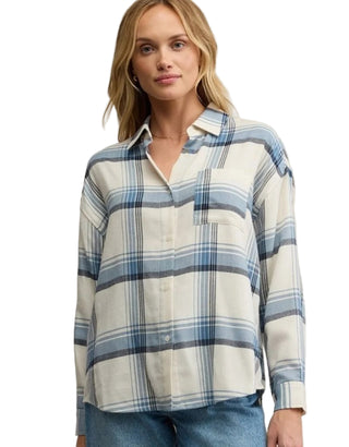Woman wearing a blue and white plaid shirt against a beige background