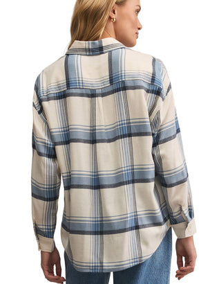 Person wearing a plaid shirt with a neutral background