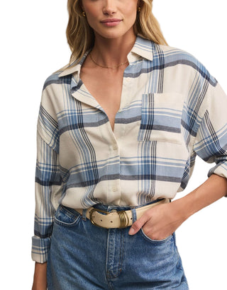 Woman wearing a plaid shirt and jeans against a neutral background