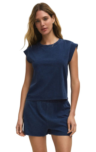 Woman wearing a blue top and shorts set on a beige background