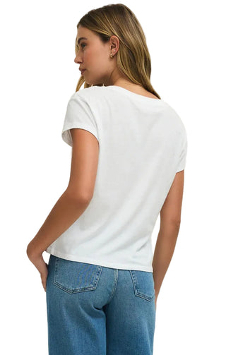 Woman wearing a white t-shirt and blue jeans on a beige background
