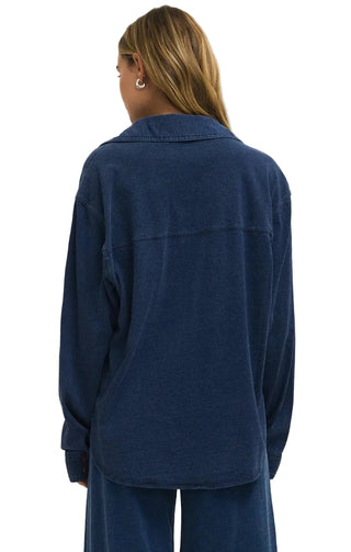 Person wearing a blue jacket and pants on a plain background