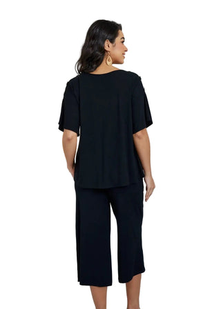 Woman wearing a black outfit in a modern interior setting