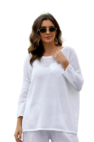 Woman in a white outfit standing outdoors with palm trees in the background