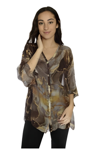 Woman wearing a patterned blouse against a white background