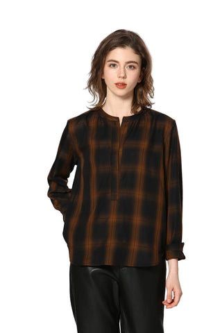 Woman wearing a brown and black checkered shirt against a white background