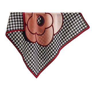 Decorative scarf with a large flower design and houndstooth border on a white background.