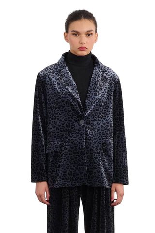 Person wearing a leopard print coat on a plain background