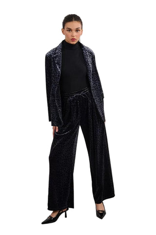 Woman wearing a black velvet suit with a white background