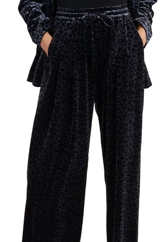 Black leopard print pants worn by a person against a white background