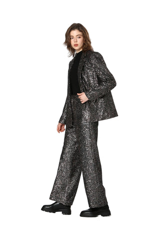 Person wearing a sparkling black suit on a white background