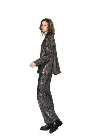 Person wearing a black sequin suit on a white background