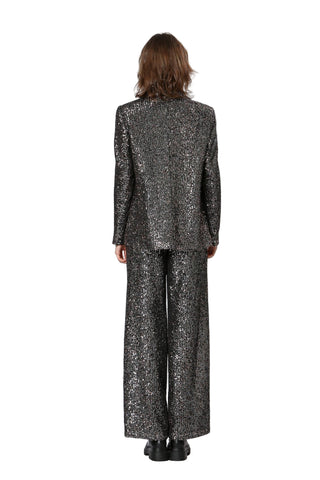 Person wearing a black sequin suit on a white background