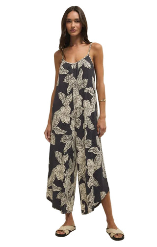 Woman wearing a navy floral jumpsuit on a white background