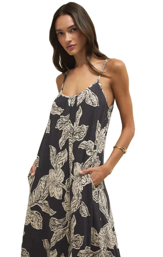 Woman wearing a navy floral dress against a plain background